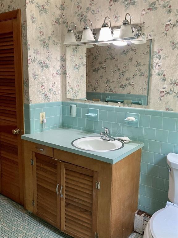 68 Briarbrook Dr, Seekonk, MA 02771 - bathroom with wallpapered walls, tile walls, a wainscoted wall, toilet, and vanity