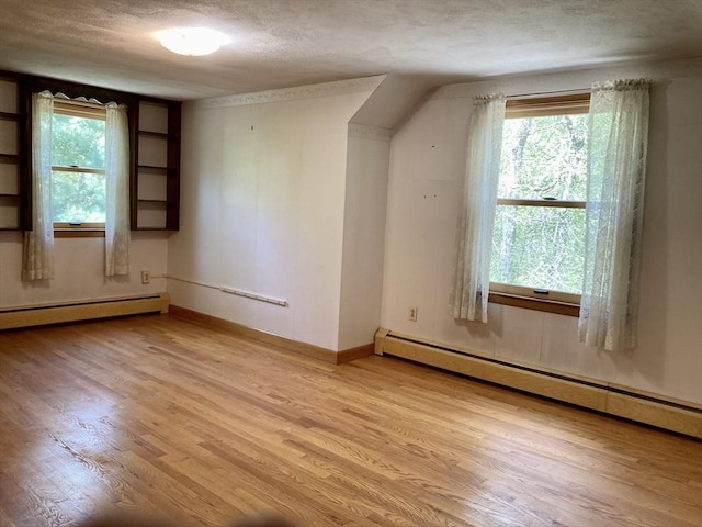 68 Briarbrook Dr, Seekonk, MA 02771 - additional living space with a baseboard heating unit, light wood-type flooring, plenty of natural light, and a textured ceiling