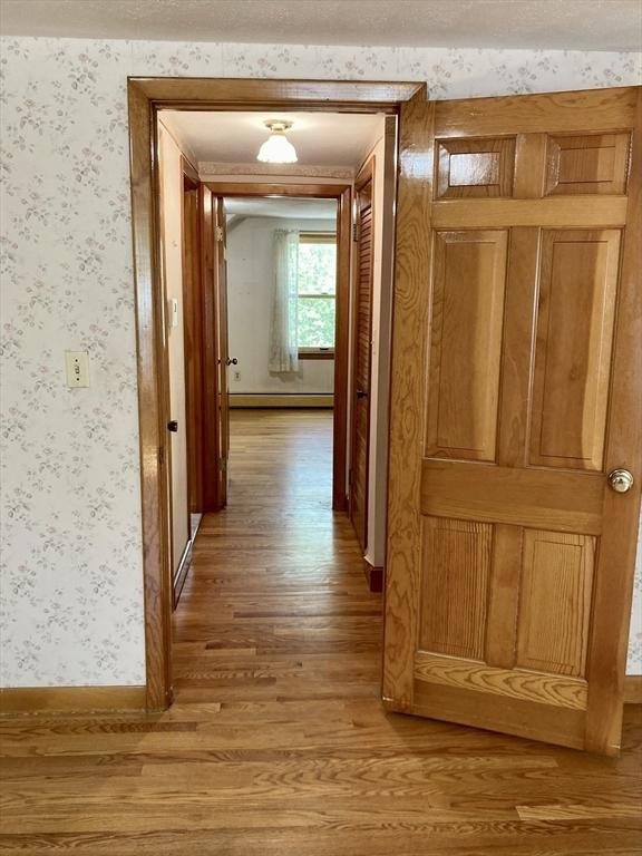 68 Briarbrook Dr, Seekonk, MA 02771 - hall with light wood finished floors, wallpapered walls, baseboard heating, and baseboards