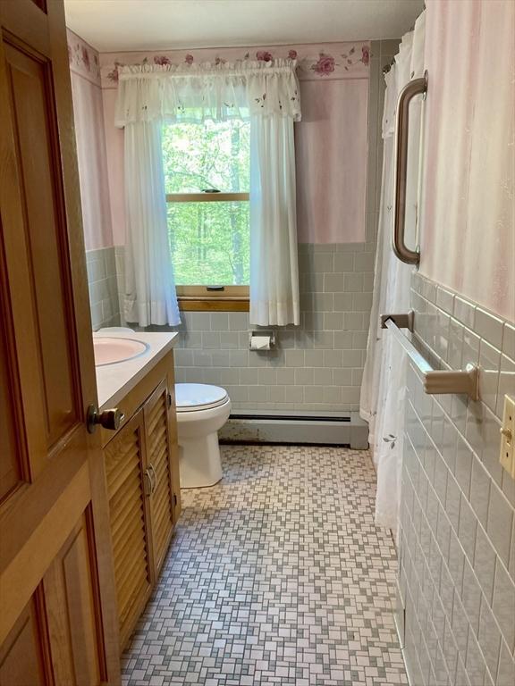 68 Briarbrook Dr, Seekonk, MA 02771 - full bath with baseboard heating, tile walls, toilet, vanity, and a wainscoted wall
