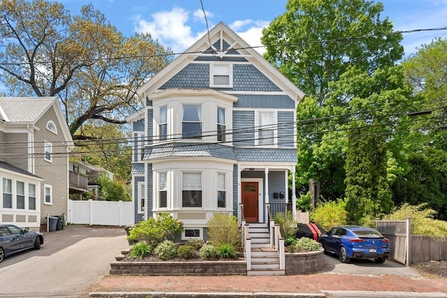 4 Arlington St Unit A, Newburyport, MA 01950 - victorian house with fence, a balcony, and asphalt driveway