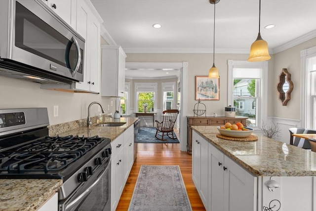 4 Arlington St Unit A, Newburyport, MA 01950 - kitchen with appliances with stainless steel finishes, a sink, light wood-type flooring, healthy amount of natural light, and ornamental molding