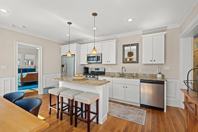 4 Arlington St Unit A, Newburyport, MA 01950 - kitchen featuring stainless steel appliances, a sink, crown molding, a kitchen island, and a kitchen breakfast bar