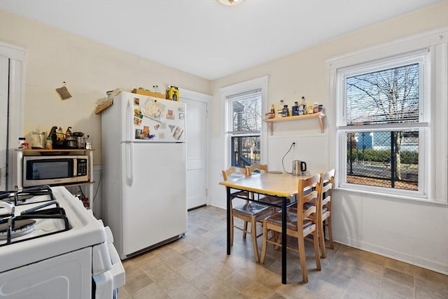 dining room featuring baseboards and a healthy amount of sunlight