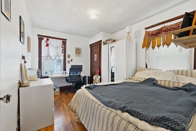 bedroom featuring light wood-style flooring and a textured ceiling