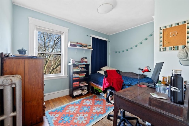 bedroom featuring crown molding, baseboards, and wood finished floors