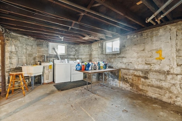 below grade area with water heater, washer and clothes dryer, and a sink