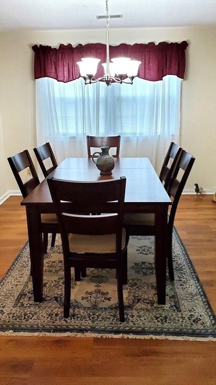 728 Auburn St Unit F8, Whitman, MA 02382 - dining space with a chandelier and wood finished floors