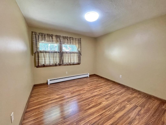 2 Bushy Ln, Rutland, MA 01543 - unfurnished room with baseboard heating, wood finished floors, and a textured ceiling