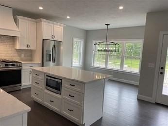 288 Fisher Rd, Holden, MA 01520 - kitchen with stainless steel appliances, custom exhaust hood, light countertops, white cabinetry, and backsplash