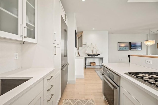 266 Merrimac St Unit F, Newburyport, MA 01950 - kitchen with stainless steel appliances, white cabinets, light wood-style flooring, recessed lighting, and light countertops