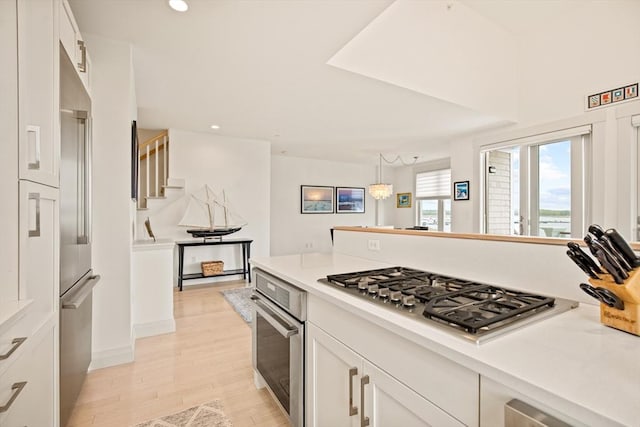 266 Merrimac St Unit F, Newburyport, MA 01950 - kitchen featuring appliances with stainless steel finishes, white cabinets, light wood-style floors, light countertops, and recessed lighting