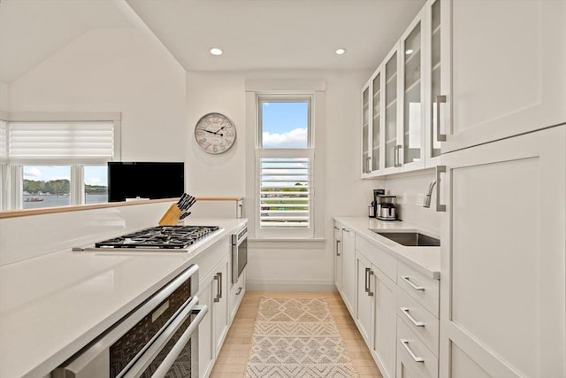 266 Merrimac St Unit F, Newburyport, MA 01950 - kitchen with a sink, baseboards, white cabinetry, glass insert cabinets, and recessed lighting