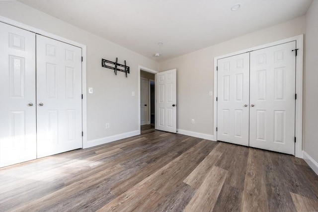 unfurnished bedroom with dark wood-type flooring