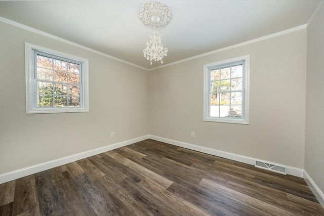 empty room with ornamental molding, an inviting chandelier, and dark wood-type flooring