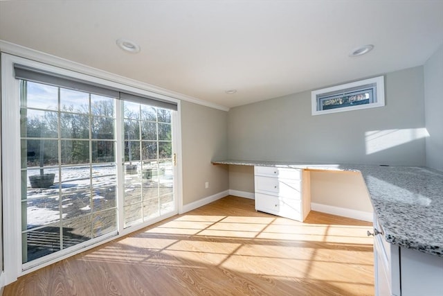 unfurnished office with light wood-type flooring and built in desk