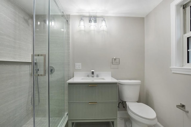 bathroom featuring vanity, a shower stall, toilet, and baseboards