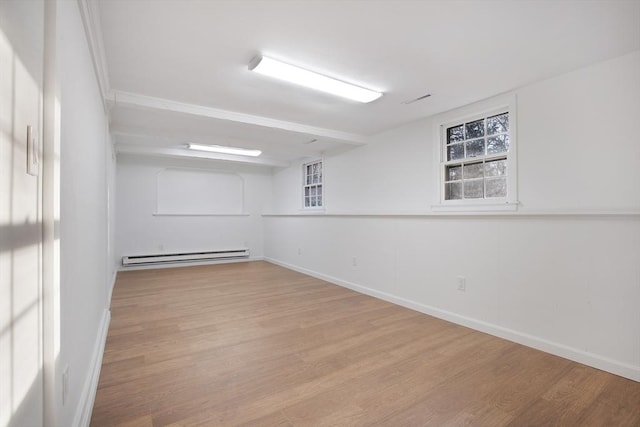 spare room featuring visible vents, wood finished floors, baseboards, and baseboard heating