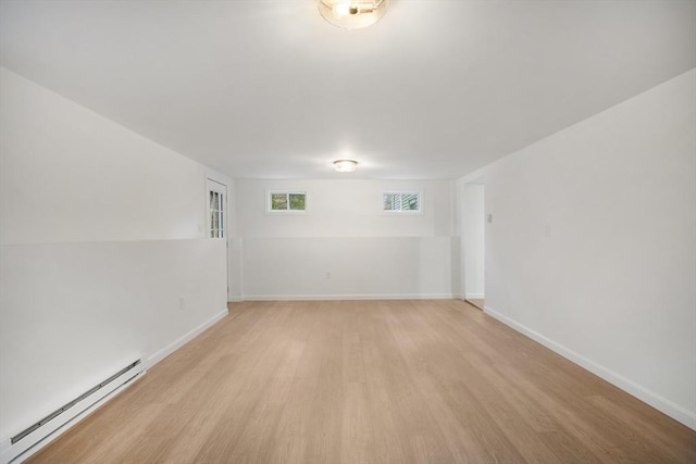 unfurnished room featuring visible vents, light wood-type flooring, a baseboard heating unit, and baseboards