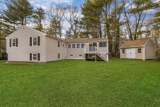 back of property with stairs, an outbuilding, a lawn, and a sunroom