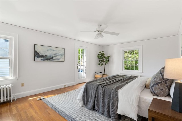 bedroom with baseboards, radiator heating unit, light wood-type flooring, and ceiling fan