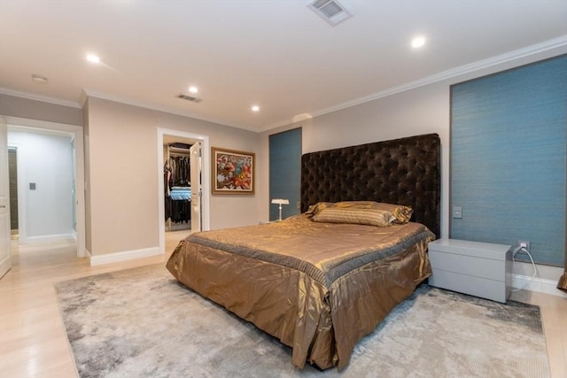 bedroom with visible vents, baseboards, a walk in closet, and light wood finished floors