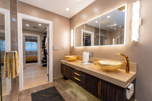 bathroom featuring visible vents, a sink, recessed lighting, double vanity, and walk in shower