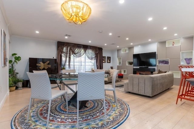 dining room featuring visible vents, light wood-style flooring, recessed lighting, ornamental molding, and a chandelier