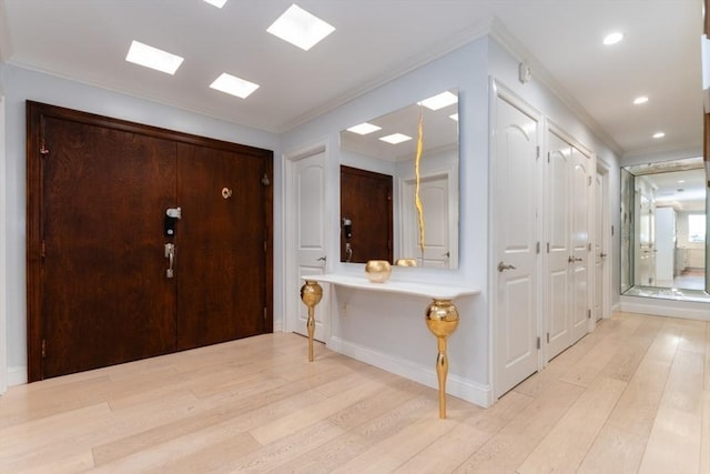 entryway featuring recessed lighting, baseboards, crown molding, and light wood-style floors