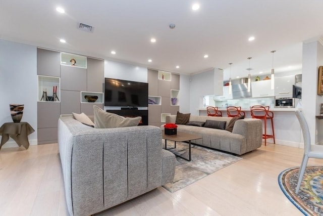 living area featuring recessed lighting, visible vents, and light wood finished floors