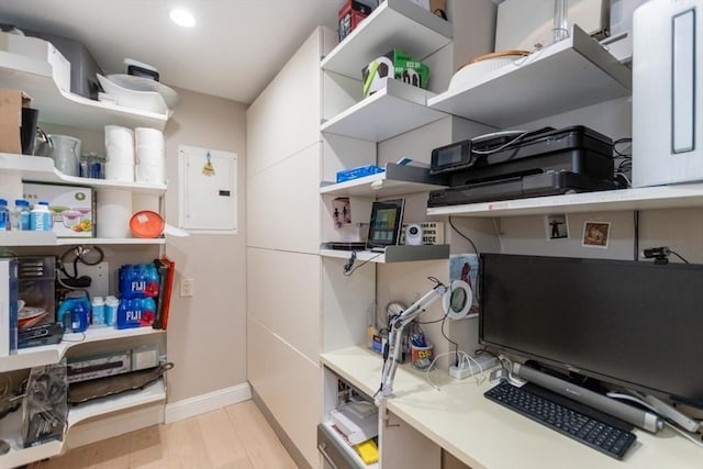 interior space featuring open shelves, electric panel, light wood-style floors, and light countertops