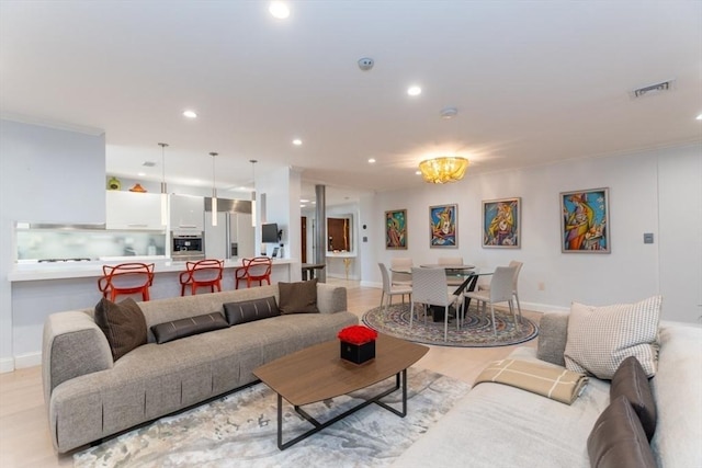 living room with recessed lighting, visible vents, light wood finished floors, and baseboards