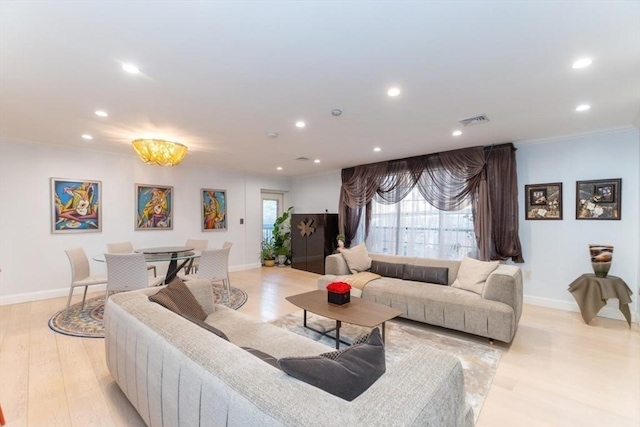 living area featuring recessed lighting, visible vents, light wood-style flooring, and ornamental molding