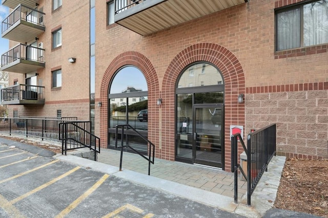 entrance to property featuring uncovered parking and brick siding