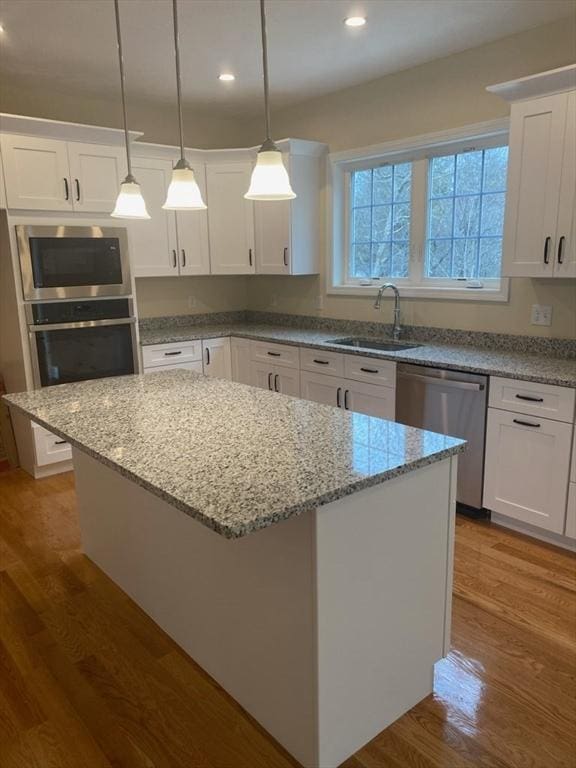 kitchen featuring stainless steel appliances, white cabinets, and sink