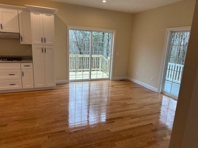 unfurnished dining area featuring light wood-type flooring