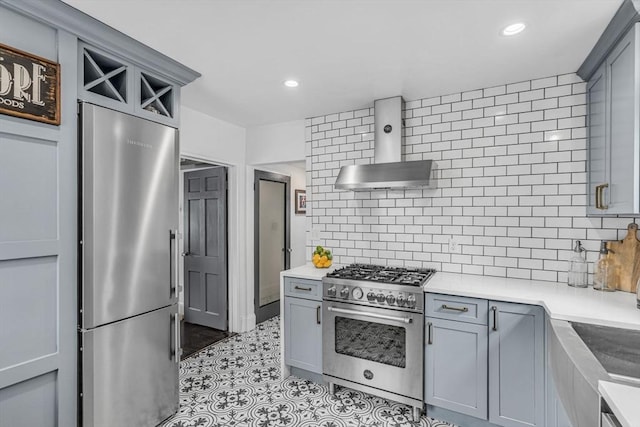 5 Vandergrift St, Lawrence, MA 01843 - kitchen with appliances with stainless steel finishes, wall chimney range hood, gray cabinetry, backsplash, and recessed lighting