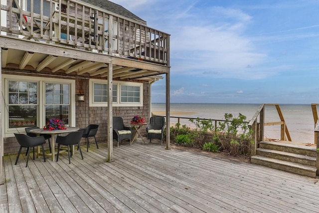 deck featuring a water view and a beach view