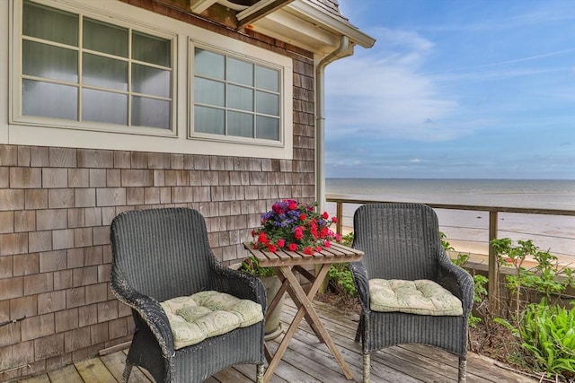 balcony with a water view and a view of the beach