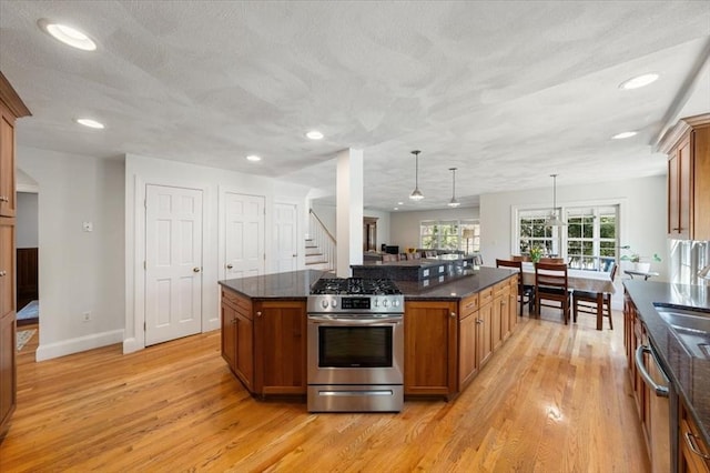 76 Union St, Natick, MA 01760 - kitchen with stainless steel gas range, recessed lighting, brown cabinetry, and light wood-style floors