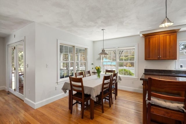 76 Union St, Natick, MA 01760 - dining room featuring baseboards, a textured ceiling, and light wood-style flooring