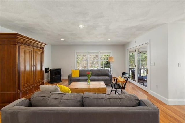 76 Union St, Natick, MA 01760 - living room with recessed lighting, baseboards, a wood stove, and light wood-type flooring