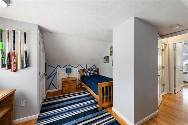 76 Union St, Natick, MA 01760 - bedroom with baseboards, a textured ceiling, lofted ceiling, and wood finished floors