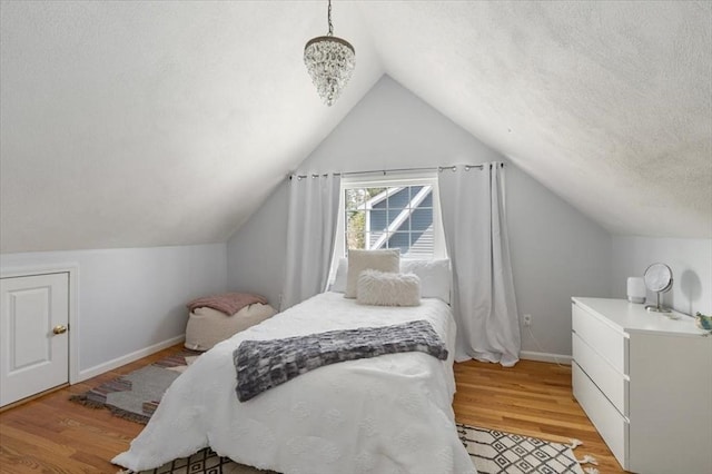76 Union St, Natick, MA 01760 - bedroom with light wood-style floors, baseboards, vaulted ceiling, and a textured ceiling