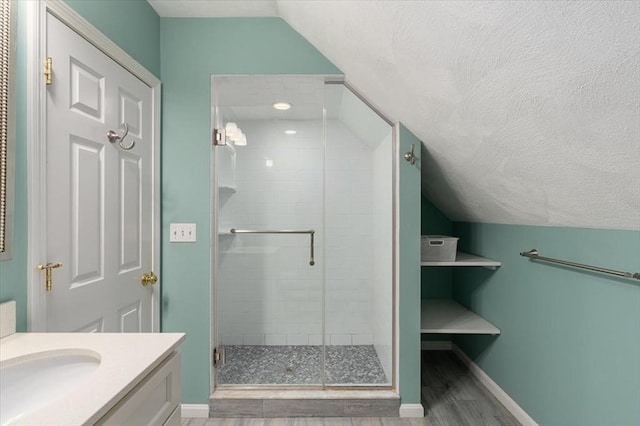 76 Union St, Natick, MA 01760 - full bath with vanity, lofted ceiling, baseboards, a textured ceiling, and a shower stall