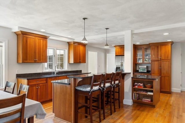 76 Union St, Natick, MA 01760 - kitchen featuring brown cabinets, stainless steel fridge, a sink, and a center island