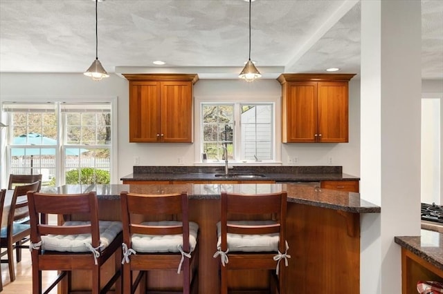 76 Union St, Natick, MA 01760 - kitchen with a sink, brown cabinetry, and decorative light fixtures