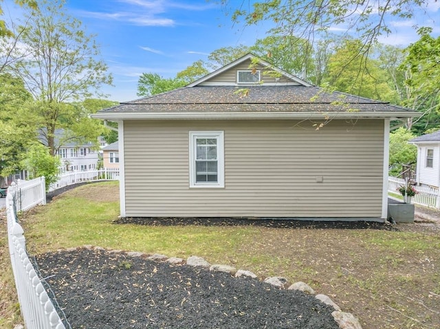 view of side of home with roof with shingles