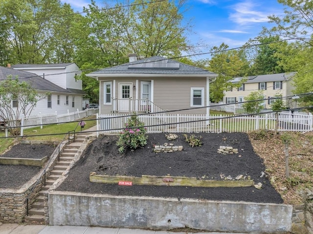 view of front of home featuring a chimney and a garden