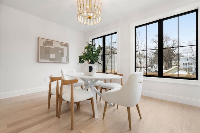 dining space featuring a notable chandelier and light hardwood / wood-style floors